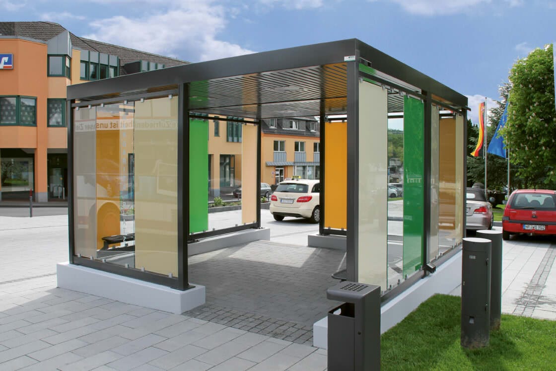 Überdachungssysteme von WSM können den individuellen Anforderungen angepasst werden. In diesem Fall integriert sichder Aufenthaltsbereich durch Glasfarben harmonisch ins Stadtbild der direkten Umgebung.
